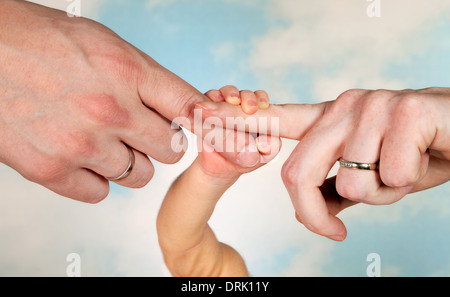 Te le mani di un bambino e i suoi genitori con gli anelli di nozze Foto Stock