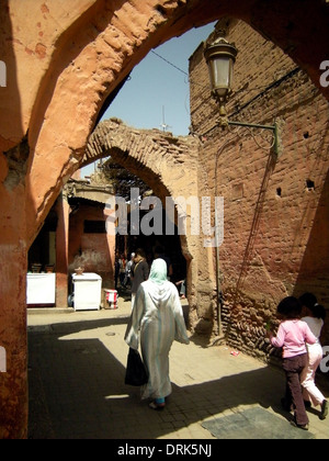 La Marrakechi andare circa le loro attività quotidiane in una scena di strada tipici di quella che si trova nella città di Medina a baldacchino, Marrakech, Foto Stock