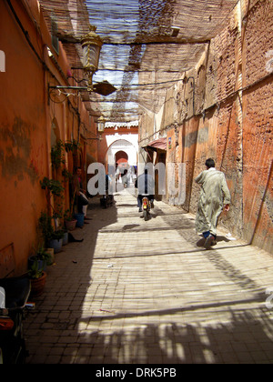 La Marrakechi andare circa le loro attività quotidiane in una scena di strada tipici di quella che si trova nella città di Medina a baldacchino, Marrakech, Foto Stock