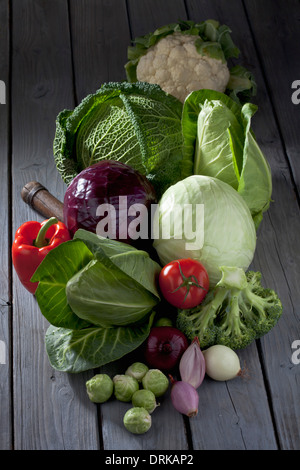 Varietà di cavolo e altre verdure su grigio tavolo in legno Foto Stock