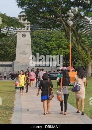 Persone che camminano con il Cenotafio monumento in background in Singapore Foto Stock