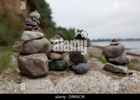 Torri di rocce equilibrata impilati su una grande roccia in una posizione costiera in Europa. Foto Stock