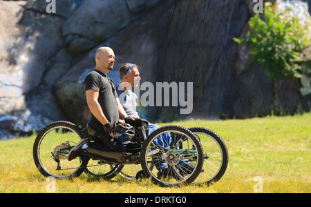 Due uomini con lesioni al midollo spinale a cavallo su off-road cicli a mano Foto Stock