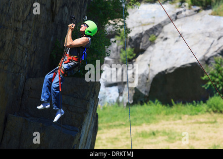 Uomo con lesioni del midollo spinale con adaptive arrampicata attrezzature per la palestra di roccia Foto Stock