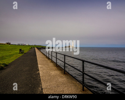 Passeggiata che conduce alla strada rialzata, all'Isola di St Mary e al faro. Whitley Bay, Tyne e Wear. Foto Stock