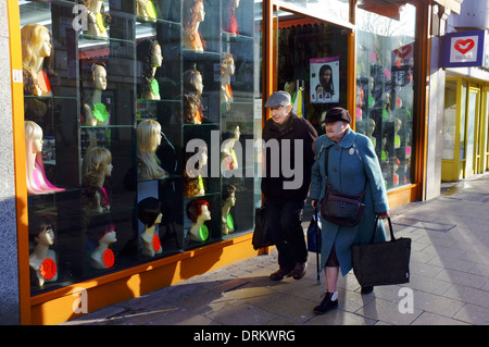I pensionati oltrepassando una parrucca Shop in Luton Foto Stock