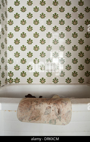 Un ammuffito bathmat appeso sul lato di una vasca da bagno in un motel abbandonato in Ontario, Canada. Foto Stock