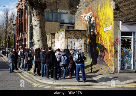 I turisti essendo guidato intorno all'arte di strada in Shoreditch area di Londra Foto Stock