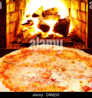 Italian pizza margherita e aprire il fuoco nella stufa a legna Foto Stock