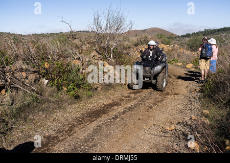 Quad bike off road tour si riunisce con i camminatori su di una pista in Santiago del Teide Tenerife, Isole Canarie, Spagna Foto Stock