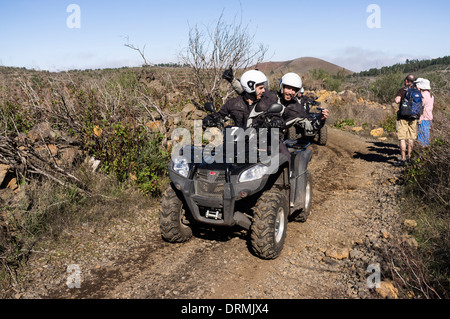 Quad bike off road tour si riunisce con i camminatori su di una pista in Santiago del Teide Tenerife, Isole Canarie, Spagna Foto Stock