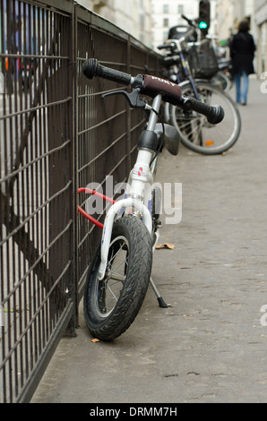 Bike bambino attaccato alla recinzione in ferro a Parigi, Francia. Foto Stock