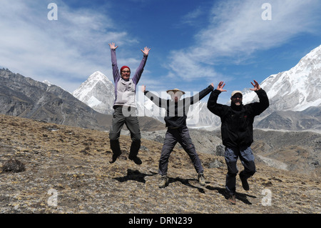 Escursionisti tre salti di gioia sul campo base Everest trek Foto Stock