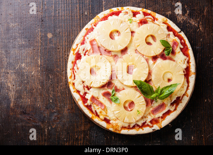 Hawaiian pizza con ananas e il prosciutto su un tavolo di legno Foto Stock