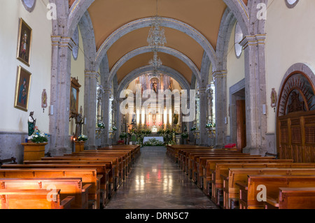 Interno della Chiesa in Messico Chapala con colonne ed archi formando la navata e altare illuminato Foto Stock