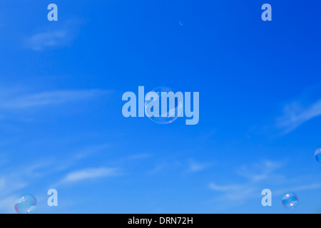 Bolle di sapone galleggianti nel cielo blu Foto Stock