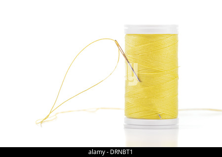 Filo giallo e un ago isolato su sfondo bianco. Foto Stock