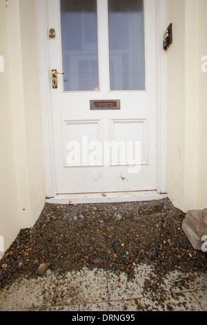 Dopo una settimana di alta marea, mareggiate e tempesta vigore venti, il lungomare di Aberystwyth in Galles è stato devastato, con milioni di £ 's di danni. Le onde che si infrangono punzonato un grande foro nella parete del mare ed è crollato Aberystwyth iconici, lungomare vittoriano rifugio, che ha resistito per oltre 100 anni. Questa foto è stata scattata mercoledì 8 gennaio, 2014, il giorno in cui il Consiglio ha cominciato a cercare di cancellare le migliaia di tonnellate di macerie spiaggia fuori di fronte al mare su strada. Foto Stock