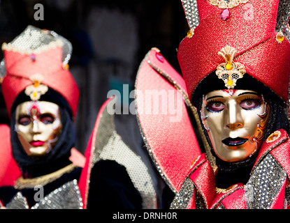 Due in costume mascherato e i partecipanti del Carnevale di Venezia rappresenta per la folla. Foto Stock