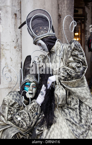Due in costume mascherato e i partecipanti del Carnevale di Venezia rappresenta per la folla. Foto Stock