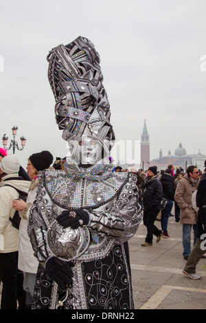 Immagine di un carnevale di Venezia partecipante in pieno il costume e la maschera di camminare tra la folla Foto Stock