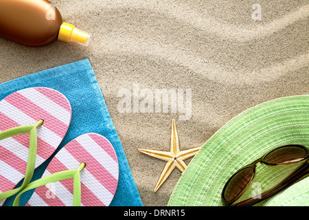 Spiaggia di sabbia con uno sfondo con asciugamano, ciabatte, cappello, occhiali da sole, olio di abbronzatura e stelle marine. Concetto di estate. Vista superiore Foto Stock