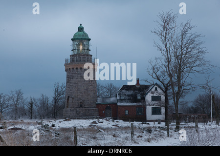 La casa di luce sul martello Knude al crepuscolo. L'inverno è arrivato e il terreno è coperto di neve. Foto Stock