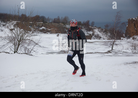 Un runner fa il suo modo attraverso la neve all'inizio della corsa. Egli è uno dei 30 odd corridori per correre la maratona edition. Foto Stock