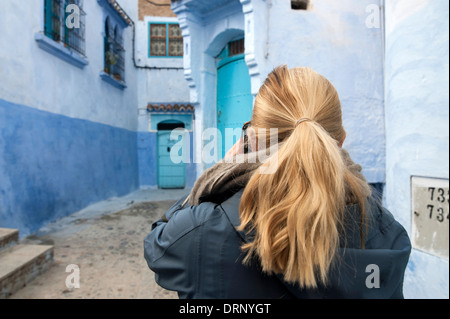 Una ragazza europea di fotografare il vicolo di Chefchaouen in Marocco Foto Stock