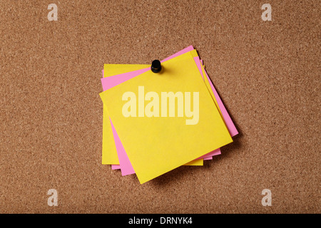 Mazzetto di vuoto sticky notes sulla bacheca di sughero Foto Stock