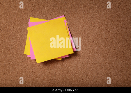 Mazzetto di vuoto sticky notes sulla bacheca di sughero Foto Stock