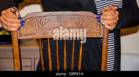 Australian bandiere dipinte sulle unghie delle mani che sono posto su un antico legno intagliato sedia con gli animali nativi Foto Stock