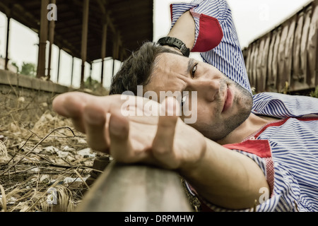 Giovane uomo disteso sulle piste e in posa Foto Stock