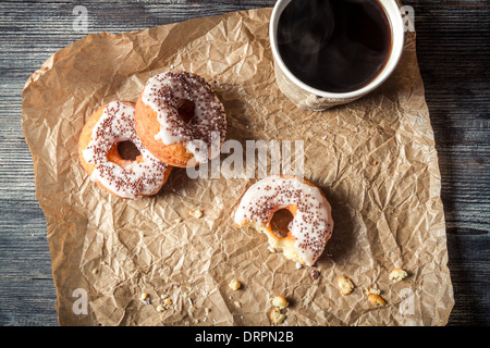 Caffè caldo e ciambelle dato nella carta Foto Stock