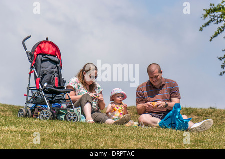 Una coppia e il loro bambino avente un picnic su Box Hill, Surrey, Inghilterra Foto Stock