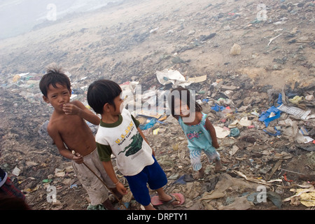 Due ragazzi e una ragazza che sono lavoratori minorenni sono raccogliere rifiuti presso il pungo Meanchey discarica in Phnom Penh Cambogia. Foto Stock