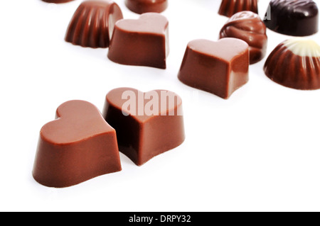 Primo piano di alcuni a forma di cuore Bonbons di cioccolato su uno sfondo bianco Foto Stock