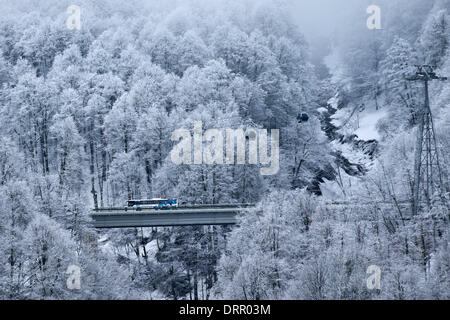 Un Olympic bus navetta è il visto sulla strada di Rosa Khutor Alpine Resort accanto a una funivia vicino a Sochi, Regione Krasnodar, Russia, 31 gennaio 2014. I Giochi Olimpici Invernali 2014 in Sochi esegui dal 07 al 23 febbraio 2014. Foto: Michael Kappeler/dpa Foto Stock