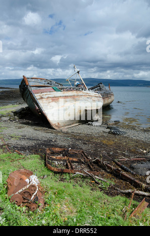 Gli scafi di tre navi per la pesca a strascico in legno marcescente e ruggine nel sole a Salen, sull'isola di Mull, Ebridi Interne, Scozia. Foto Stock