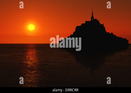 Le Mont Saint Michel silhouette con la riflessione in Normandia, Francia al tramonto Foto Stock