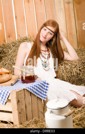 Redhead hippie donna hanno la colazione nel fienile Foto Stock