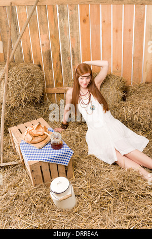 Redhead hippie donna hanno la colazione nel fienile Foto Stock