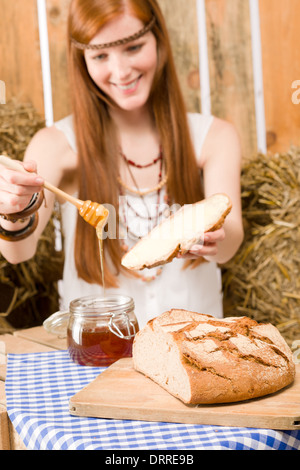 Redhead hippie donna hanno la colazione nel fienile Foto Stock