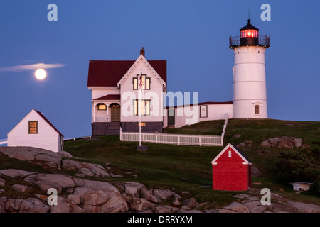 La luna piena sorge al di sopra del Capo Faro Neddick noto anche come Nubble luce in York Beach, Maine. Foto Stock