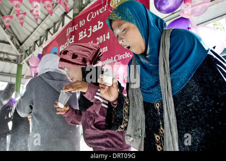 Quezon, Filippine. Il 1° febbraio 2014. Musulmani e non musulmani donne di partecipare a una partita di farina di soffiaggio al di fuori di un bicchieri di plastica durante il mondo Hijab giorno a Quezon City il 1 febbraio 2014. Nel mondo il Hijab giorno, le donne sia da musulmani e non musulmani le donne sono invitati a indossare il Hijab (velo) per un giorno per promuovere la tolleranza religiosa e capire il motivo per cui le donne musulmane indossare il hijab. Credito: Mark Fredesjed Cristino/Alamy Live News