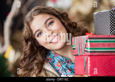 Donna attraente con i regali di Natale nel negozio Foto Stock