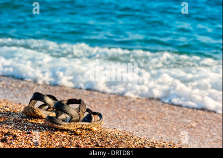 Una coppia di flip-flop a sinistra sulla riva Foto Stock