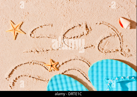 Mare ​​inscription sulla sabbia bagnata e accessori da spiaggia Foto Stock