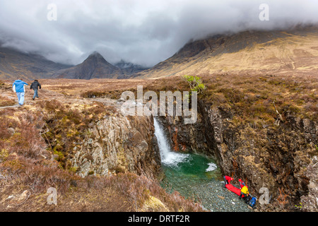 I membri del soccorso alpino di trattare un uomo che è caduto dalla cascata sul pool di fata a piedi Foto Stock