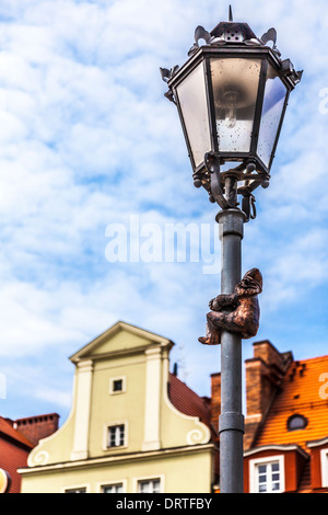 Quello di Wroclaw il famoso Bronzo poco gnomi, nani o statue krasnale scalata di un lampione in piazza del mercato della città vecchia. Foto Stock